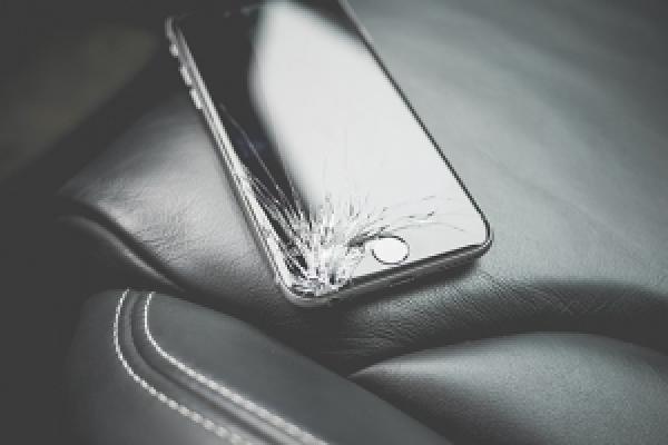 Cell phone with crack in screen on car seat in sepia
